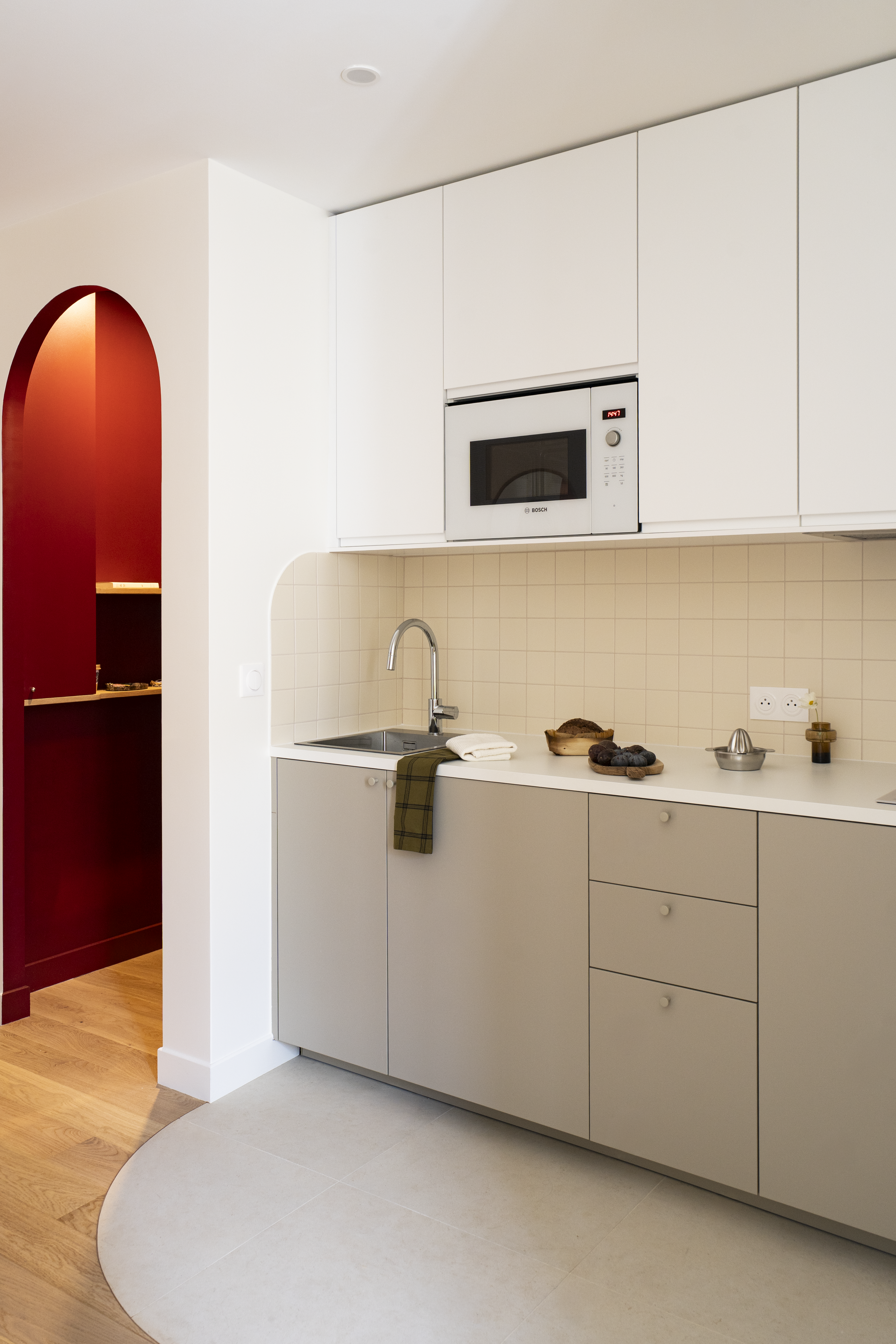 Cuisine ouverte rénovée avec arche murale arrondie et finitions sur mesure