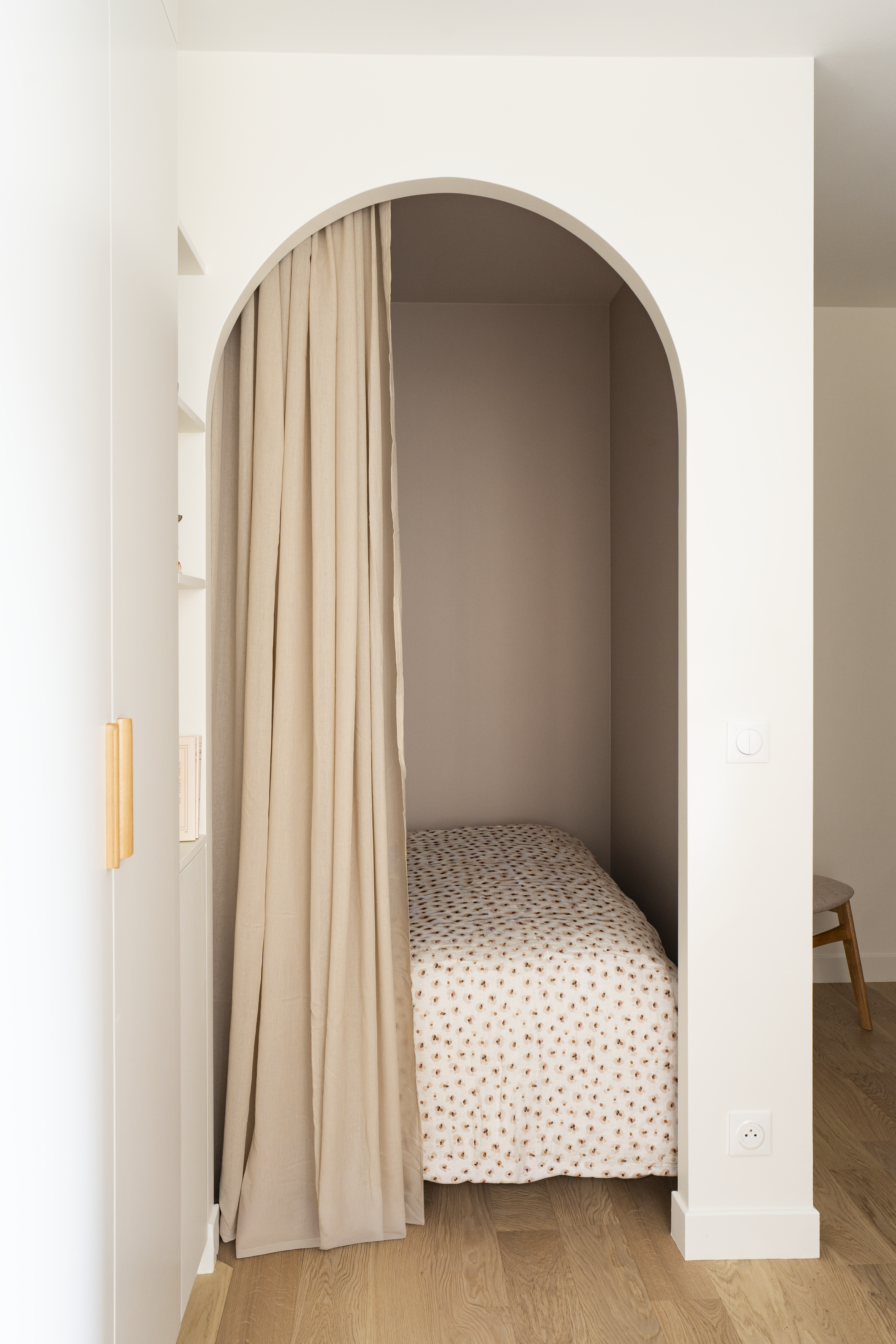 Arche arrondie avec rideau textile clair séparant les espaces dans un studio à l’aménagement intérieur contemporain