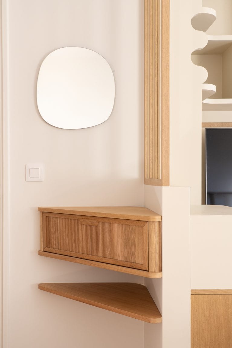 Entrée avec console murale en bois cannelé, miroir organique et étagère d'angle