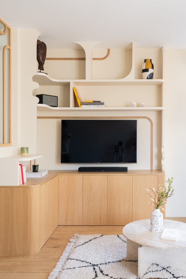 Meuble TV et bibliothèque sur mesure en chêne clair aux lignes arrondies dans un salon
