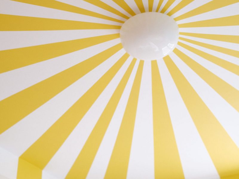Vue détaillée du plafond étoilé jaune et blanc, accentué par une suspension centrale.