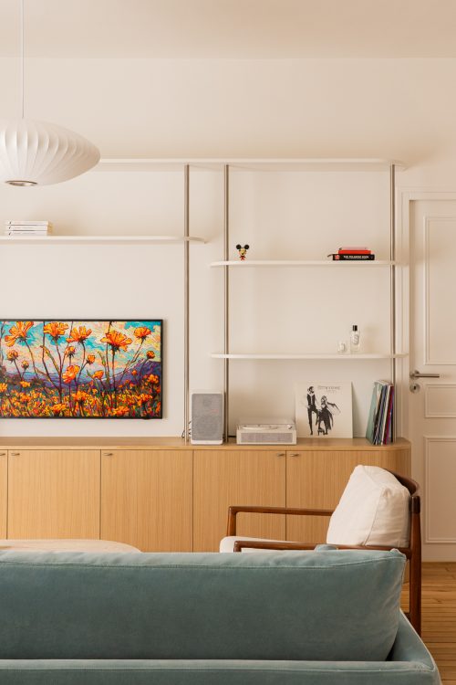 Séjour lumineux avec étagères murales, TV cadre, enfilade en chêne et suspension Nelson Bubble